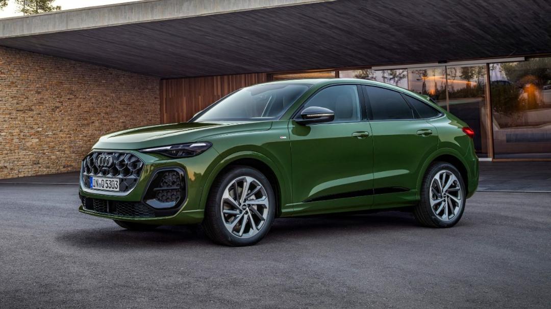 نمای نیم‌رخ از خودروی شاسی‌بلند سبز رنگ آئودی مدل Q5 Sportback در مقابل یک ساختمان مدرن