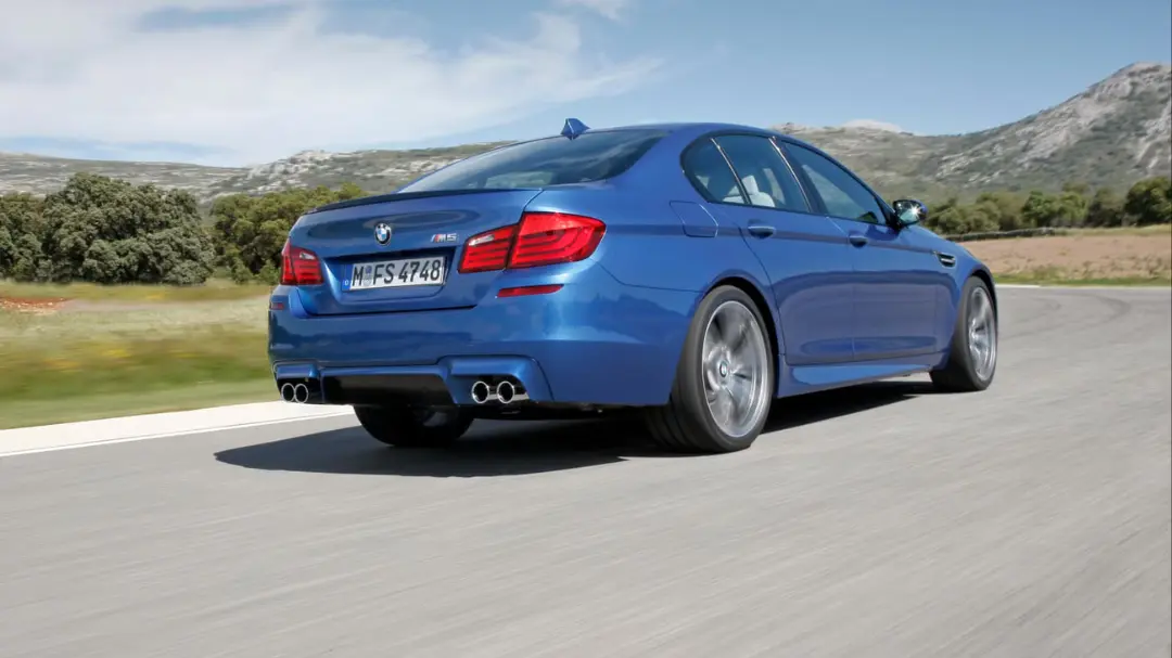 خودرو اسپرت آبی رنگ BMW M5 (BMW M5) در حال حرکت در پیست