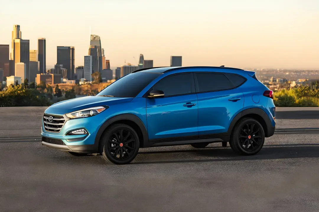 خودرو کراس‌اوور هیوندای توسان (Hyundai Tucson) آبی رنگ در مقابل خط افق شهر