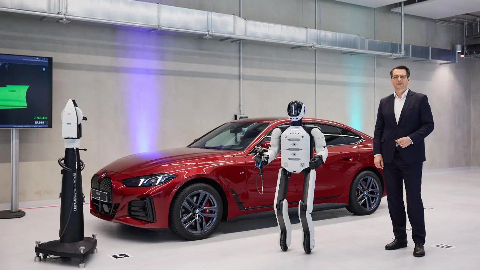 ربات انسان‌نمای هوشمند در کنار خودروی قرمز برند بی‌ام‌و (BMW)
