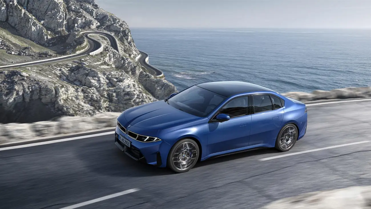 خودرو بی ام و i3 (BMW i3) آبی‌رنگ در حال حرکت در جاده ساحلی