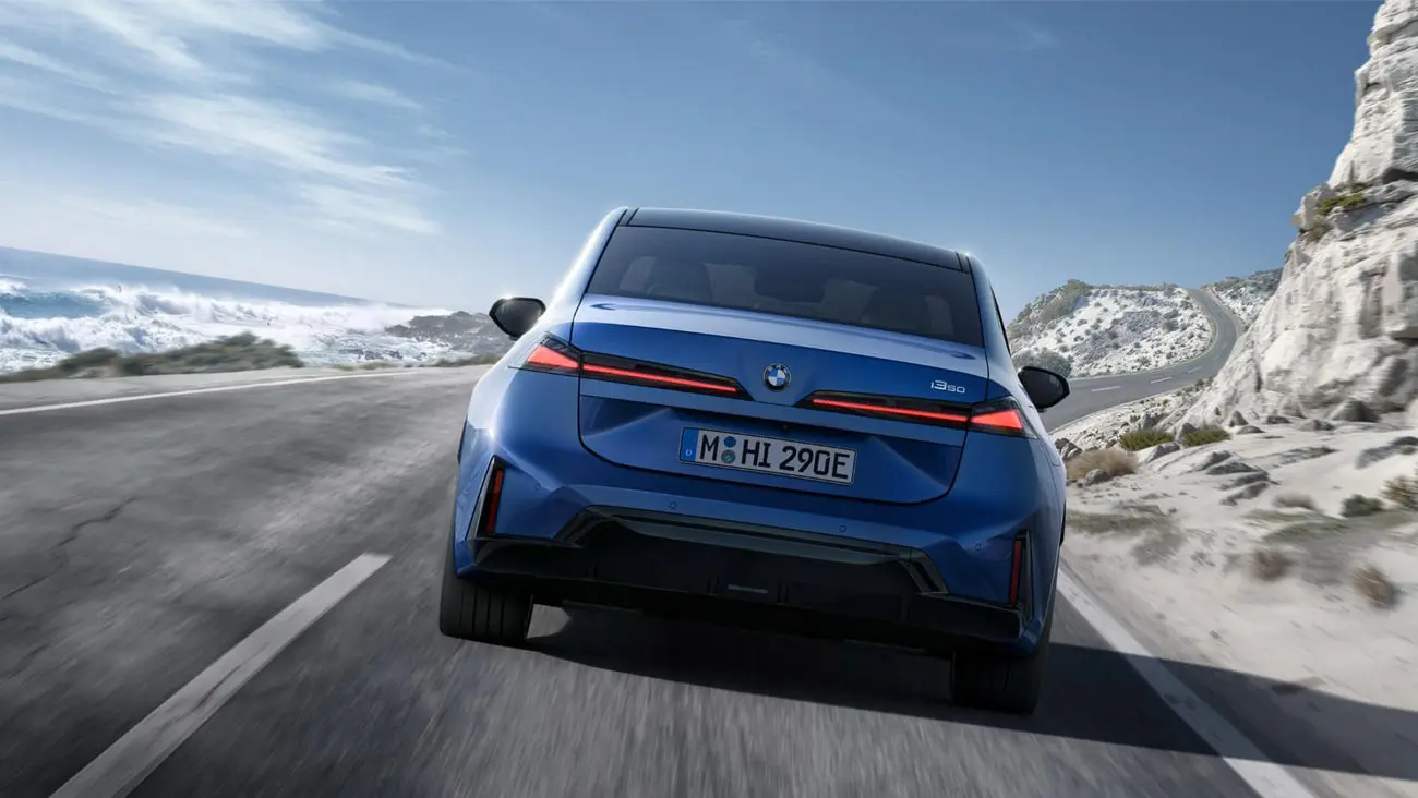 نمای عقب خودروی برقی بی ام و (BMW) i3 در حال حرکت در جاده ساحلی