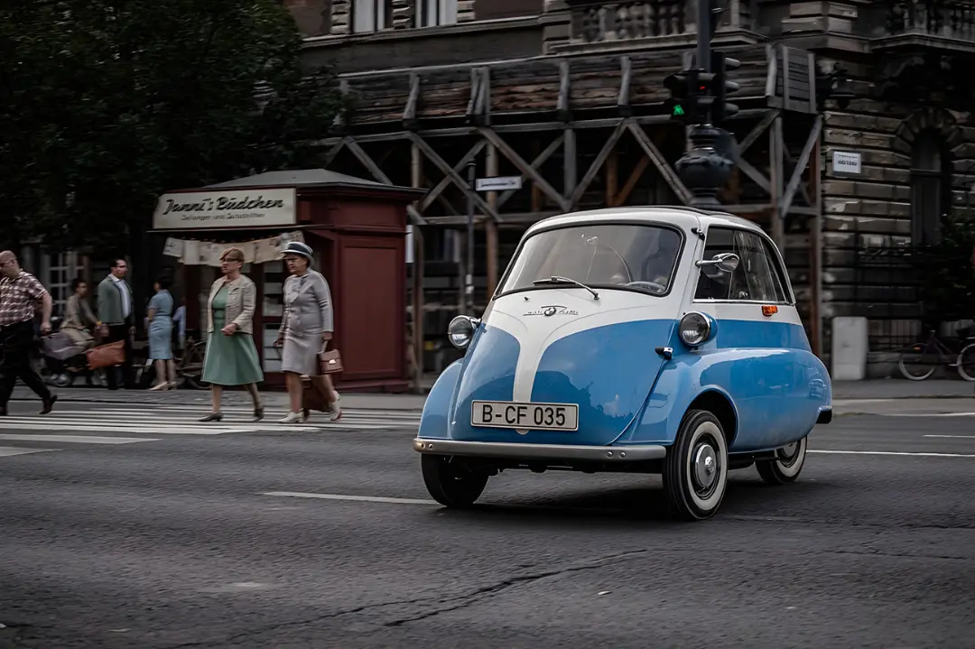 خودروی کوچک ایزتا (Isetta) با رنگ آبی و سفید در حال حرکت در خیابان