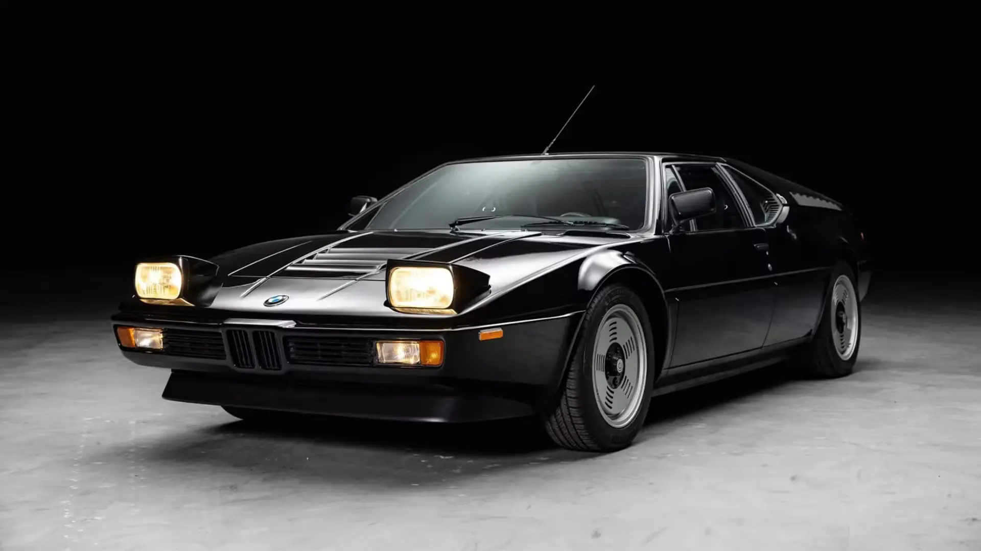 خودرو اسپرت بی‌ام‌و M1 (BMW M1) با رنگ مشکی و چراغ‌های روشن