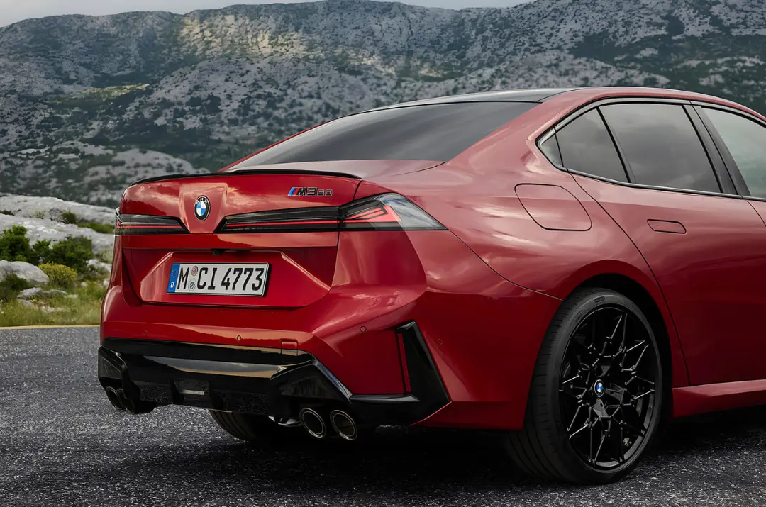 نمای عقب خودروی قرمز رنگ بی ام و (BMW) مدل M3 50 در طبیعت