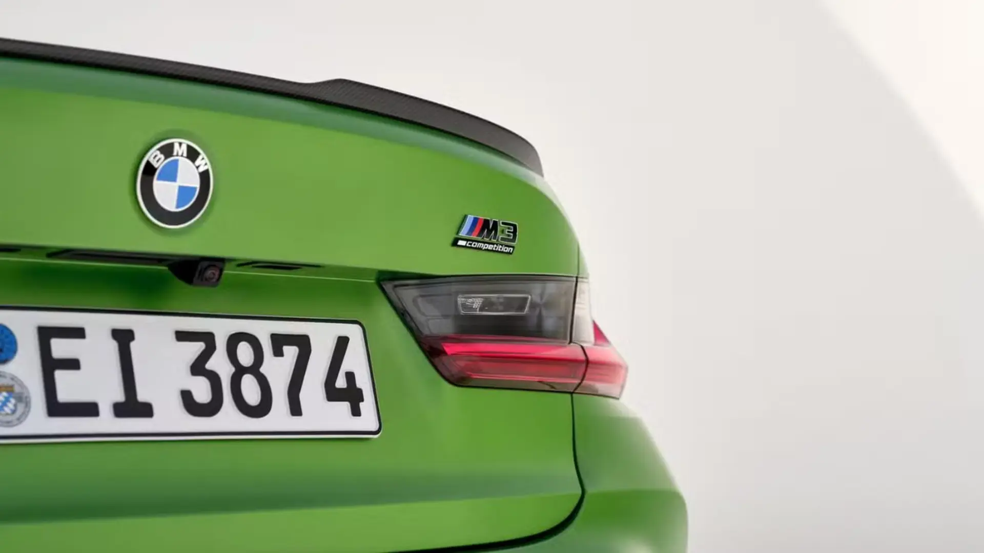 نمای نزدیک از قسمت عقب خودروی سبز رنگ بی ام دبلیو مدل M3 Competition با پلاک و لوگوی BMW