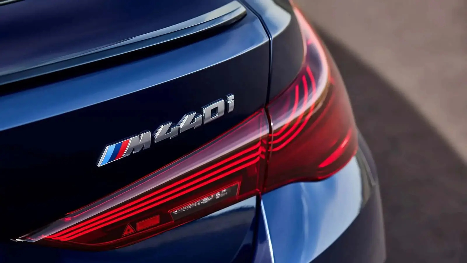 نشان مدل M440i (M440i) روی بدنه آبی رنگ خودروی بی ام و