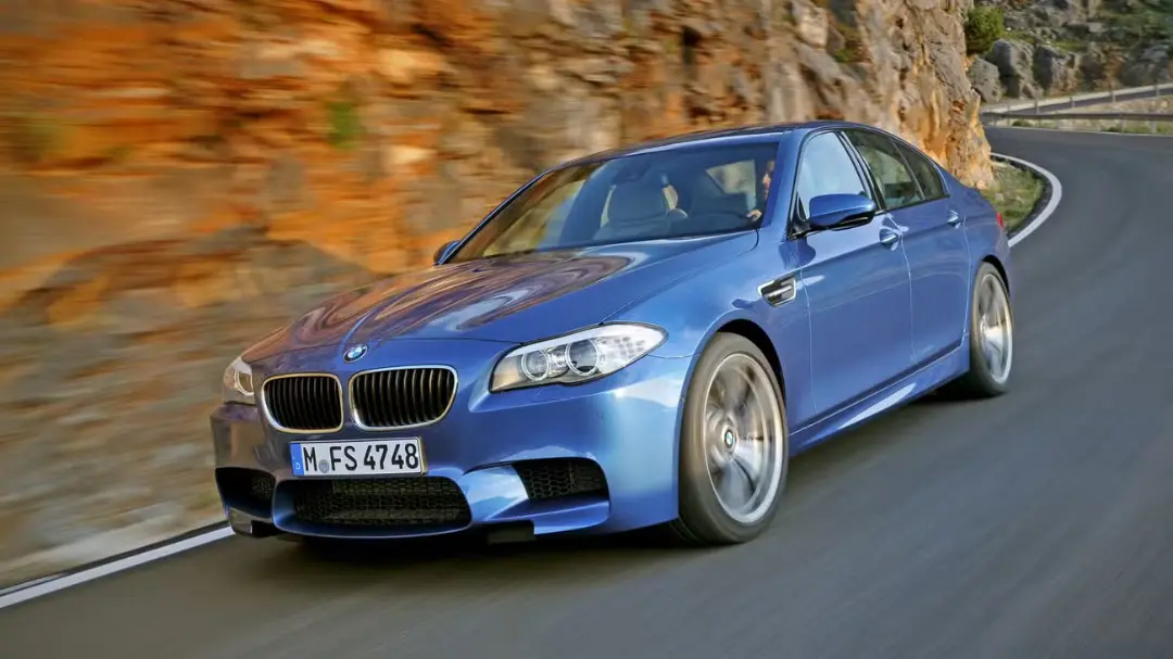 خودرو بی ام دبلیو ام ۵ (BMW M5) آبی‌رنگ در حال حرکت در جاده کوهستانی
