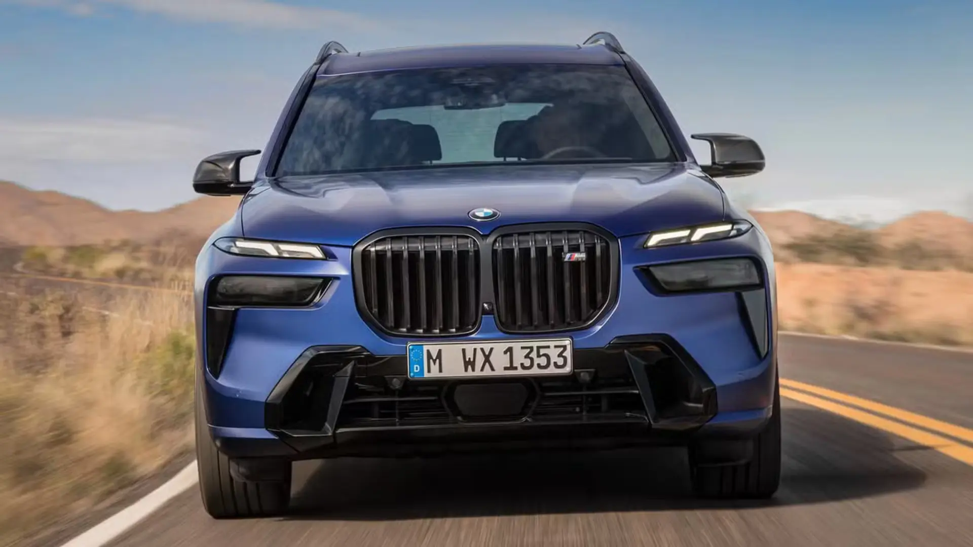 خودرو شاسی‌بلند بی ام دبلیو (BMW) آبی‌رنگ در حال حرکت در جاده