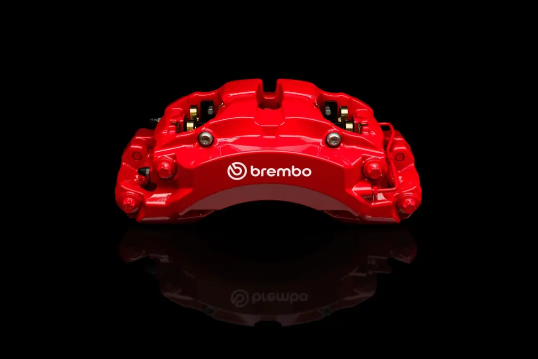 کالیپر ترمز قرمز رنگ برند برمبو (Brembo) روی پس‌زمینه سیاه