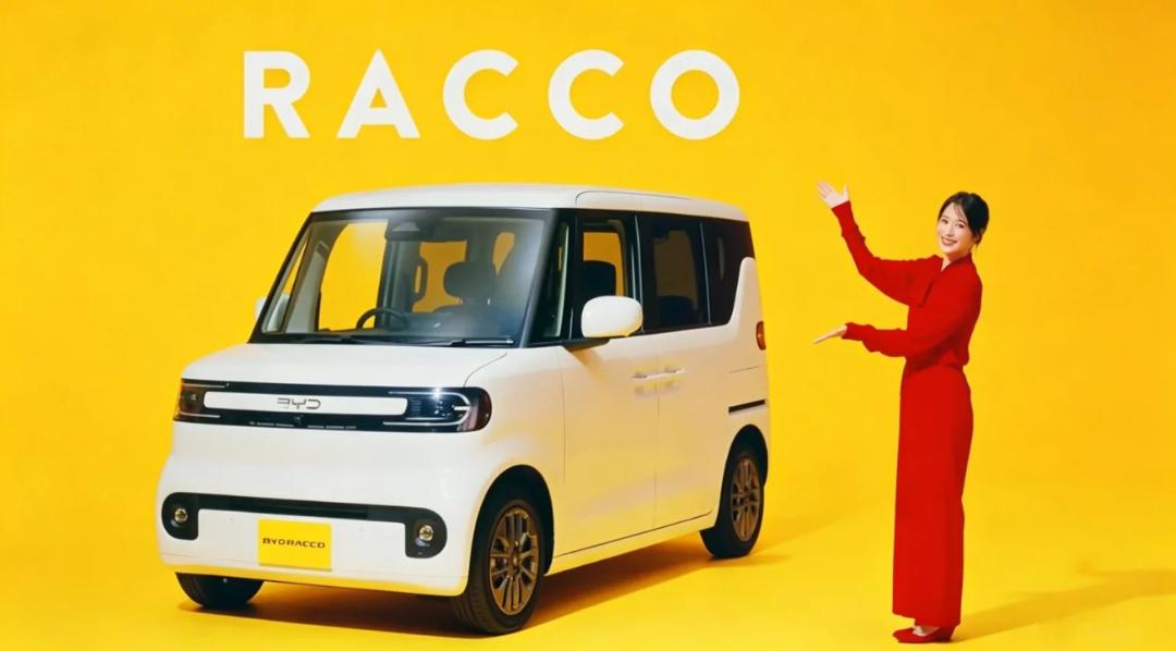 خودروی برقی کوچک و سفید رنگ مدل BYD RACCO در کنار یک خانم با لباس قرمز در پس‌زمینه زرد