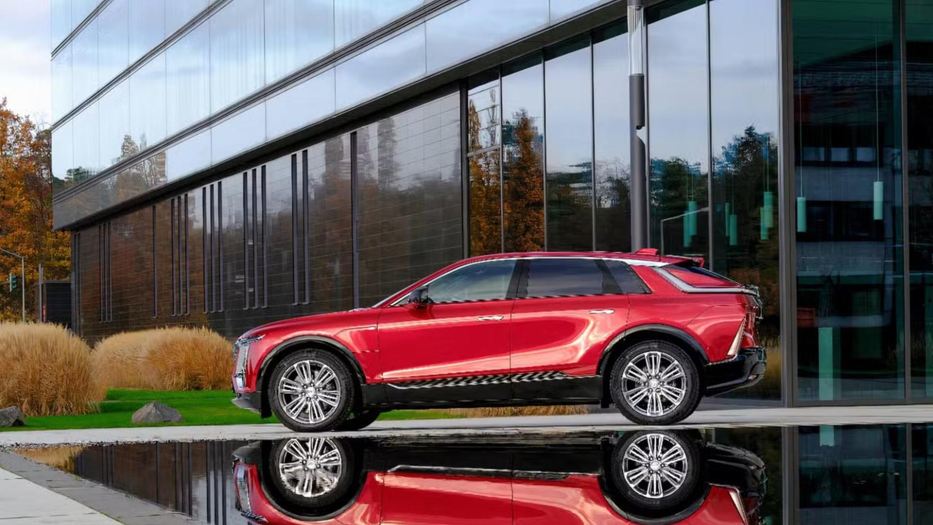 خودرو کادیلاک (Cadillac) قرمز رنگ در مقابل یک ساختمان شیشه‌ای مدرن