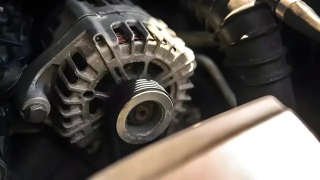 دینام خودرو (Alternator) در کنار تسمه و قطعات موتور