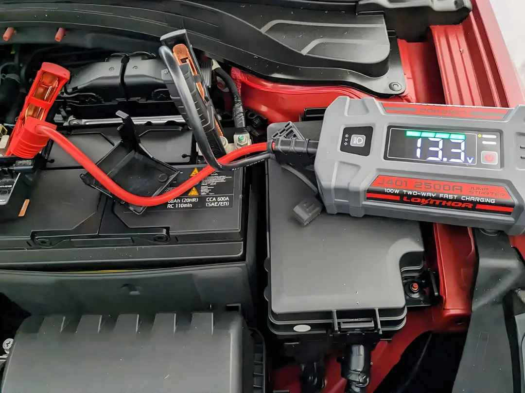 استارت کمکی (Jump Starter) متصل به قطب‌های باتری خودرو برای راه‌اندازی موتور