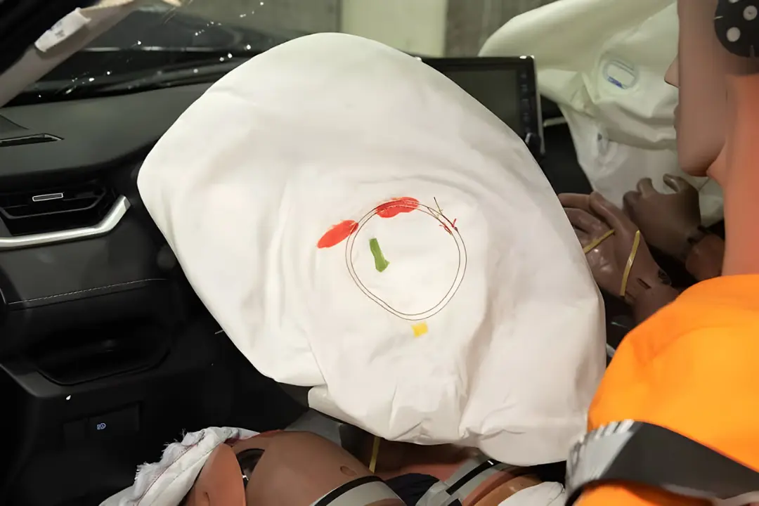 کیسه هوای باز شده (Airbag) با نشانه‌های رنگی روی سطح سفید در تست تصادف
