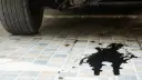 نشتی روغن سیاه رنگ خودرو روی کف کاشی پارکینگ
