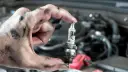شمع خودرو (Spark Plug) در دست تعمیرکار برای بررسی خرابی