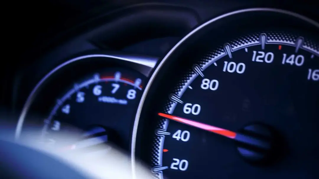 نمای نزدیک از عقربه سرعت‌سنج (Speedometer) خودرو در حال حرکت