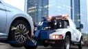 خودروی نقره‌ای متصل به خودروی یدک‌کش (Tow Truck) برای جابه‌جایی