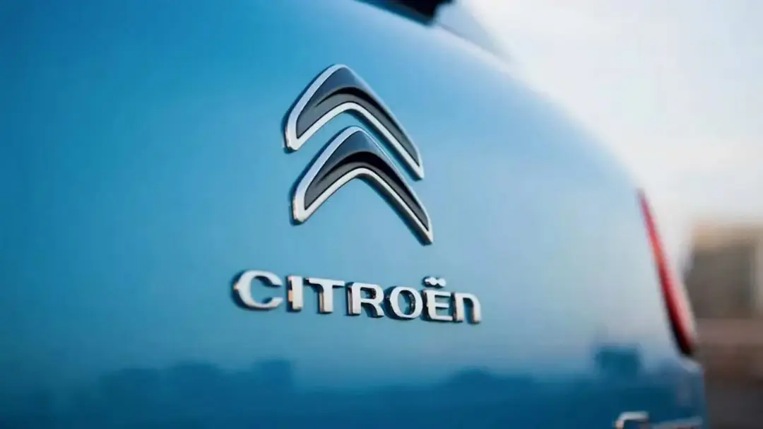 نمای نزدیک از نشان و لوگوی برند سیتروئن (Citroën) روی بدنه آبی خودرو