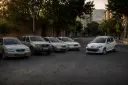 خودروهای قدیمی و کثیف در کنار یک خودروی سفید پژو (Peugeot) در خیابان