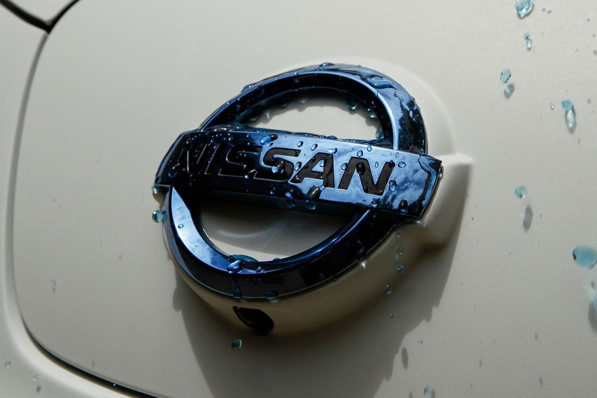 لوگوی نیسان (Nissan) روی بدنه سفید خودرو با قطرات آب
