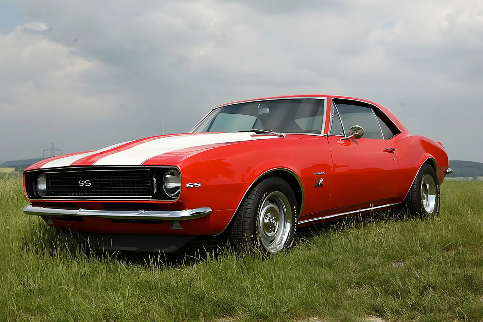 شورولت کامارو (Chevrolet Camaro) قرمز با خطوط سفید در چمنزار