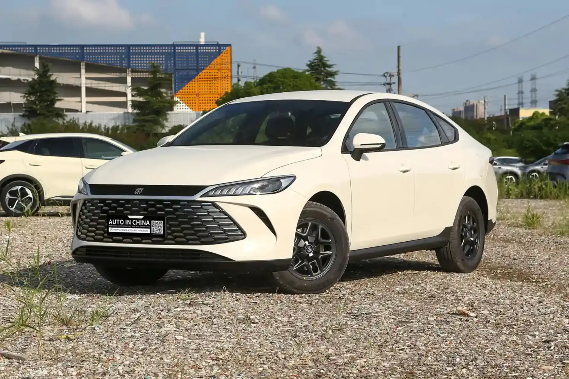 سدان سفید BYD Qin Plus در یک فضای باز و خاکی
