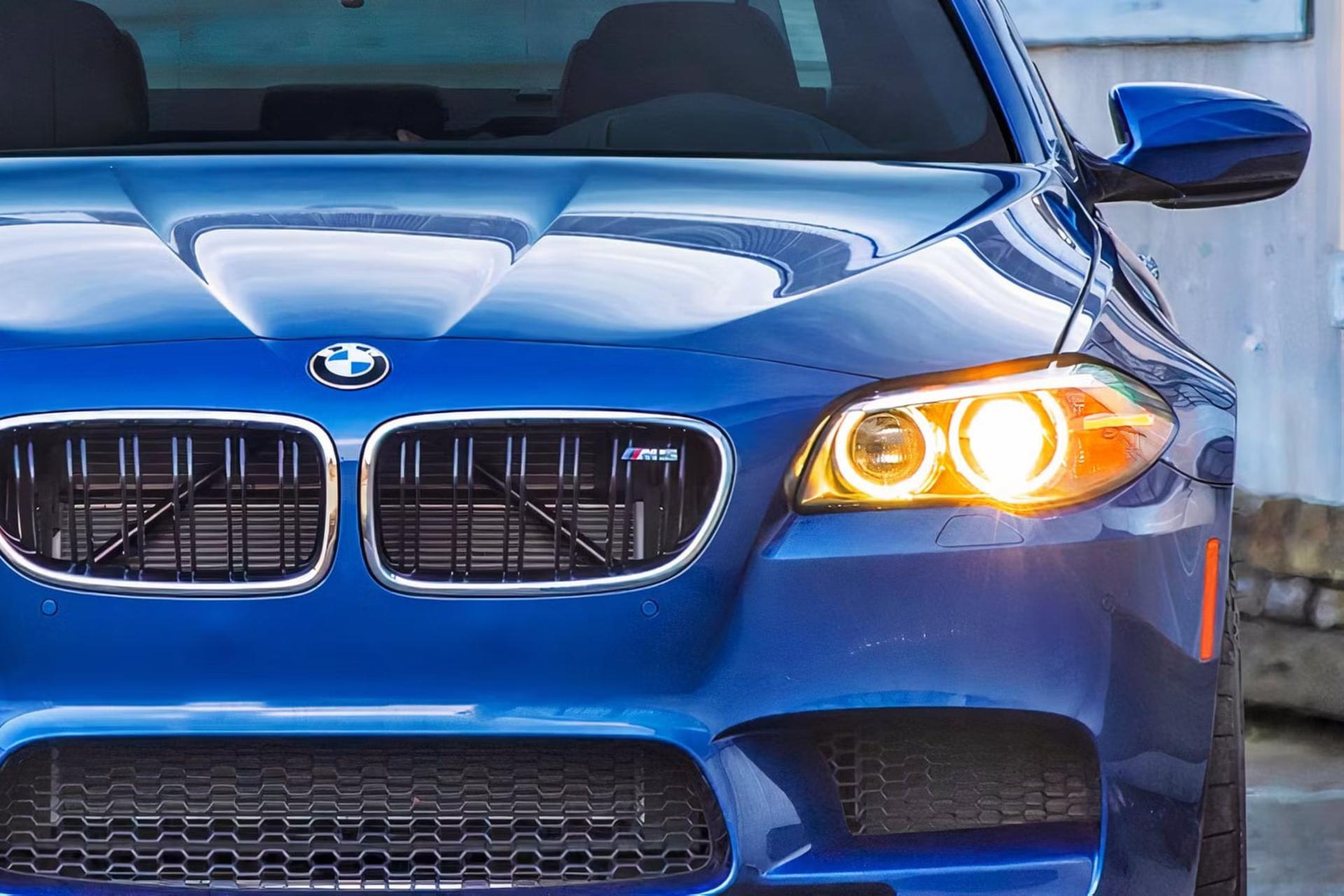 نمای نزدیک از جلوپنجره و چراغ جلوی خودروی آبی‌رنگ BMW M5 (BMW M5)
