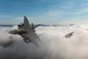جنگنده اف-ای (F/A-18) در حال پرواز میان ابرها در آسمان