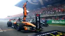لاندو نوریس (Lando Norris) روی خودروی مک‌لارن (McLaren) در پیست زاندورت ایستاده است