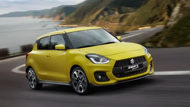 خودروی کامپکت سوزوکی سوئیفت (Suzuki Swift) زرد رنگ در حال حرکت در جاده ساحلی