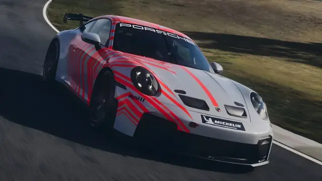 خودرو مسابقه‌ای پورشه ۹۱۱ (Porsche 911) با طرح قرمز و سفید در حال حرکت در پیست