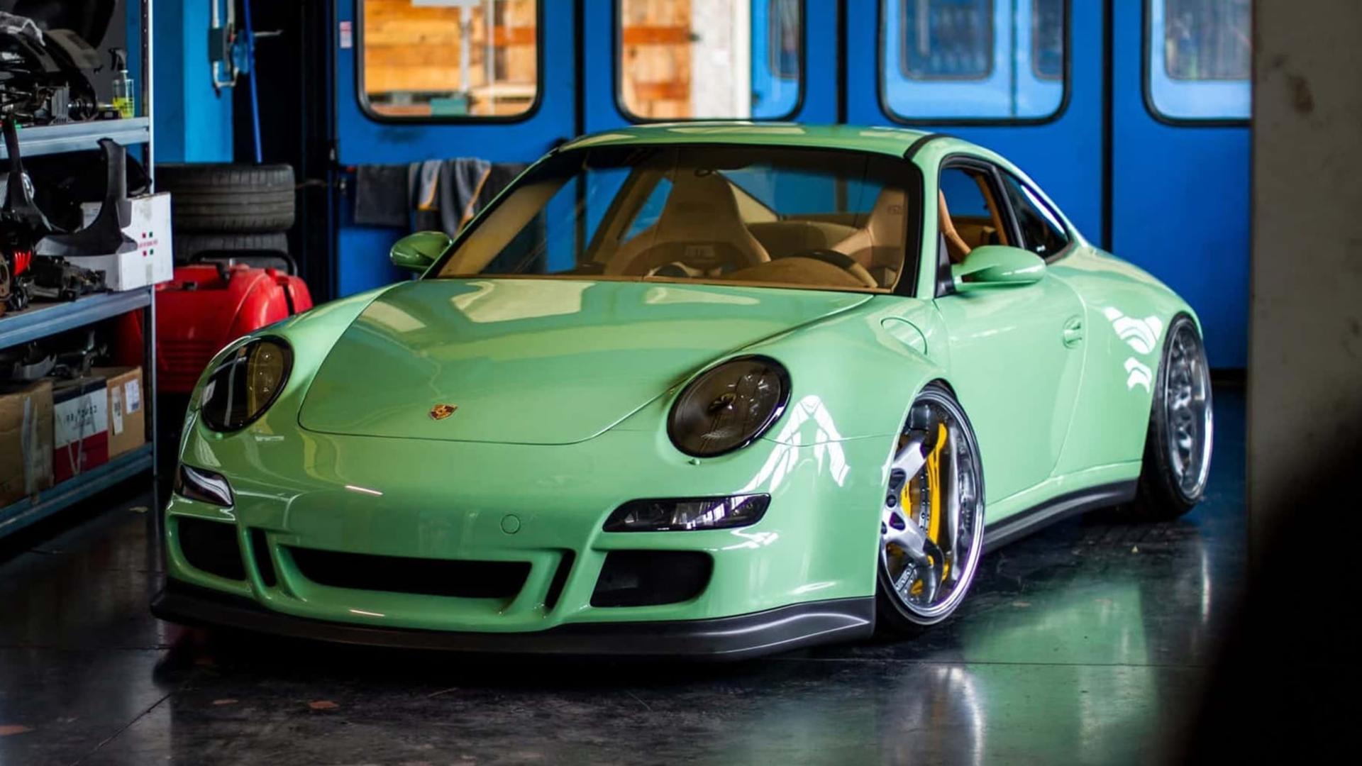 خودروی پورشه ۹۱۱ (Porsche 911) با رنگ سبز روشن و بدنه اصلاح‌شده در گاراژ