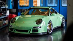 خودروی پورشه ۹۱۱ (Porsche 911) با رنگ سبز روشن و بدنه اصلاح‌شده در گاراژ