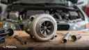 توربوشارژر (Turbocharger) خودرو روی میز کار در کنار ابزارآلات تعمیراتی