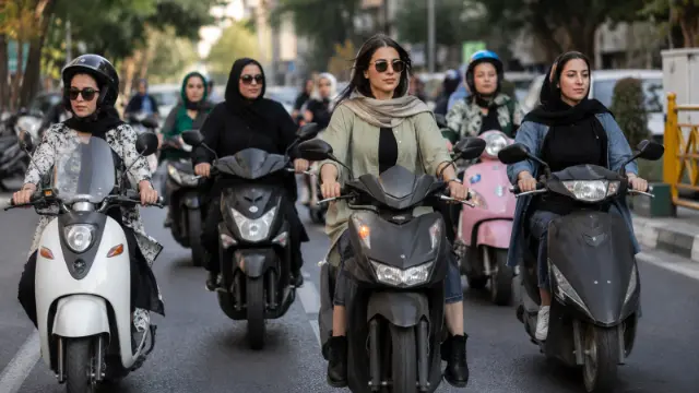 موتورسواران زن در حال رانندگی با اسکوترهای مختلف در خیابان