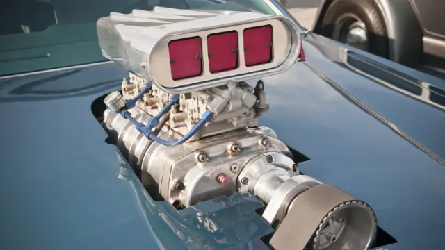 سوپرشارژر (Supercharger) نصب شده روی کاپوت یک خودروی کلاسیک با فیلتر هوا قرمز