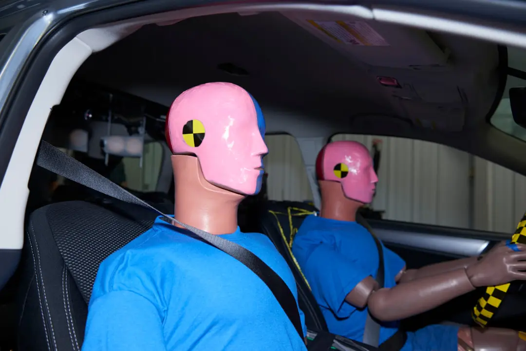 مانکن‌های تست تصادف (Crash Test Dummies) با صورت‌های صورتی در داخل کابین خودرو