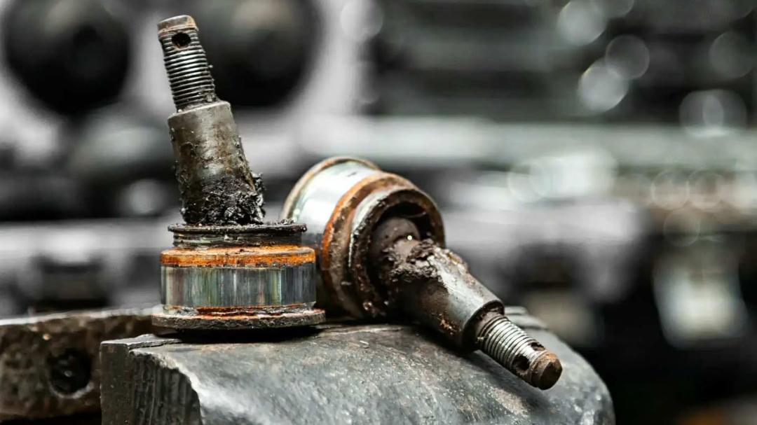 سیبک خودرو (Ball Joint) فرسوده و آسیب‌دیده با جرم و روغن سیاه