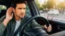 راننده خودرو در حال گوش دادن به صدای غیرعادی از فرمان
