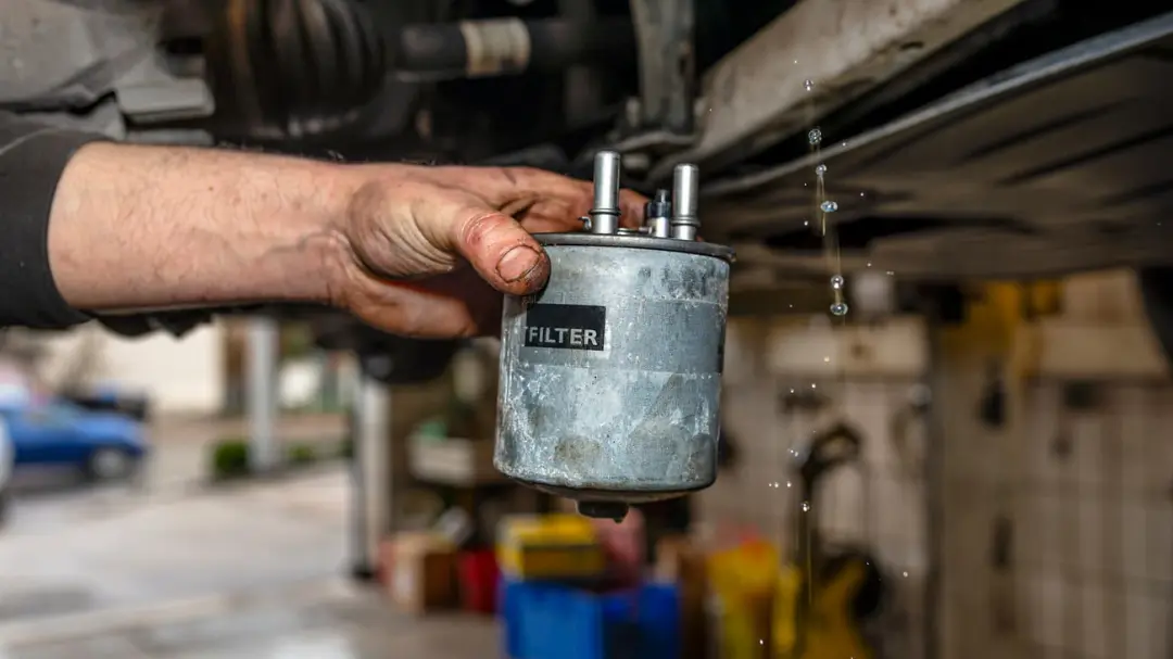فیلتر بنزین (Fuel Filter) کثیف و آسیب‌دیده در دست تعمیرکار خودرو