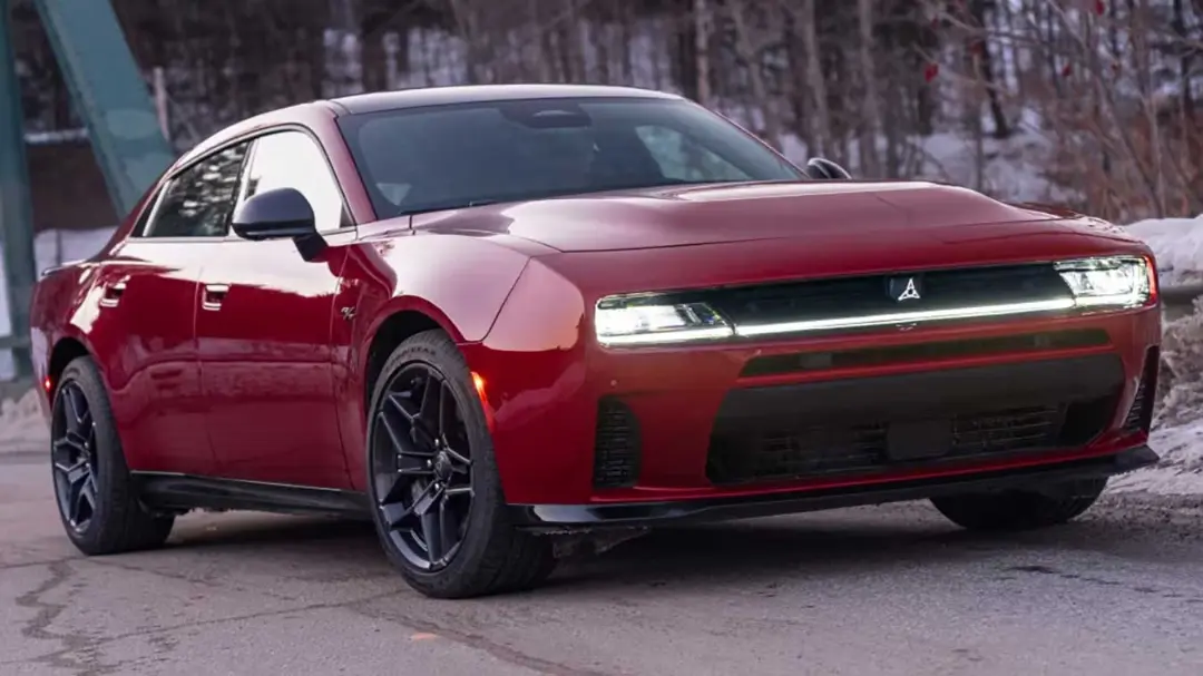 خودرو دوج چارجر (Dodge Charger) قرمز رنگ در جاده‌ای برفی