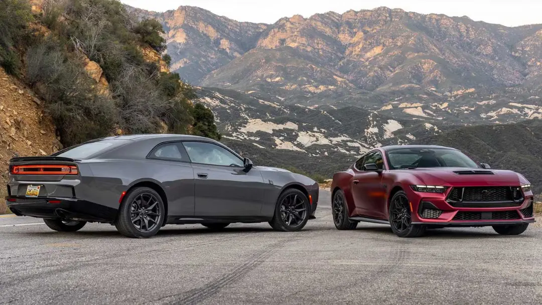 خودروهای دوج چارجر (Dodge Charger) خاکستری و فورد موستانگ (Ford Mustang) قرمز در جاده کوهستانی