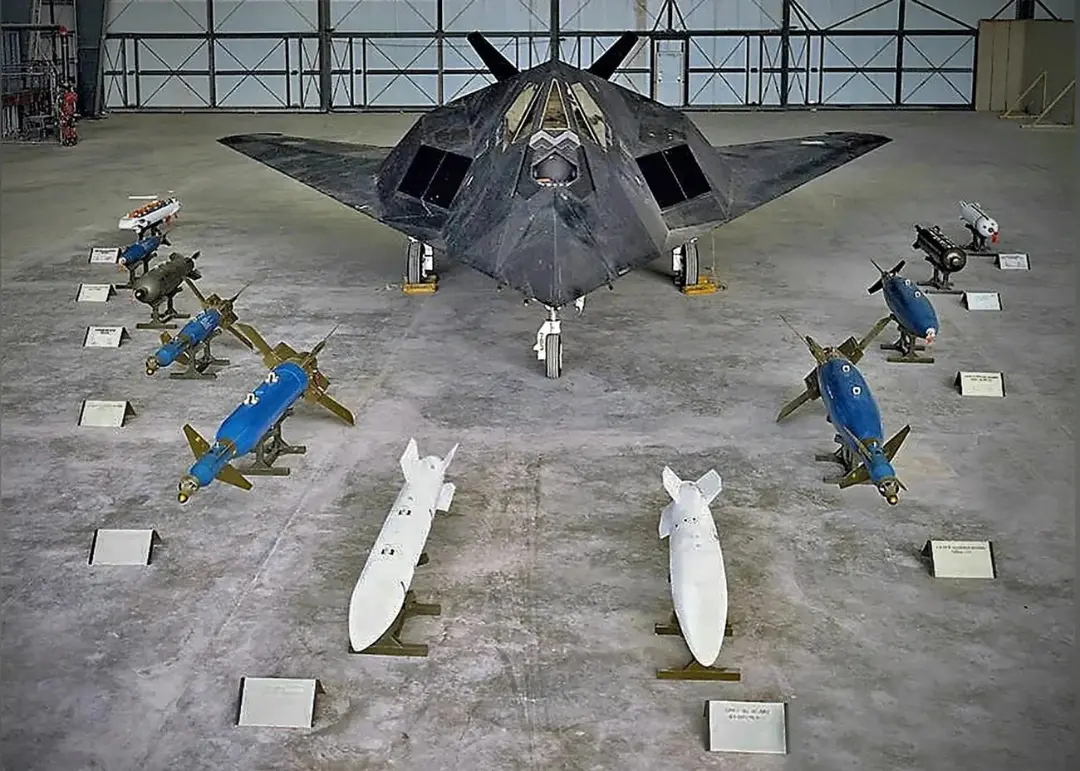 هواپیمای رادارگریز F-117 (F-117 Nighthawk) در کنار مجموعه‌ای از بمب‌ها و موشک‌ها