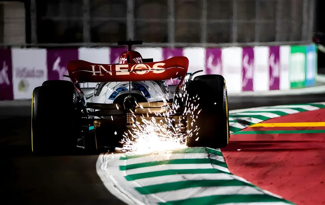 خودروی فرمول یک (Formula 1) در حال تولید جرقه با برخورد کف خودرو به پیست