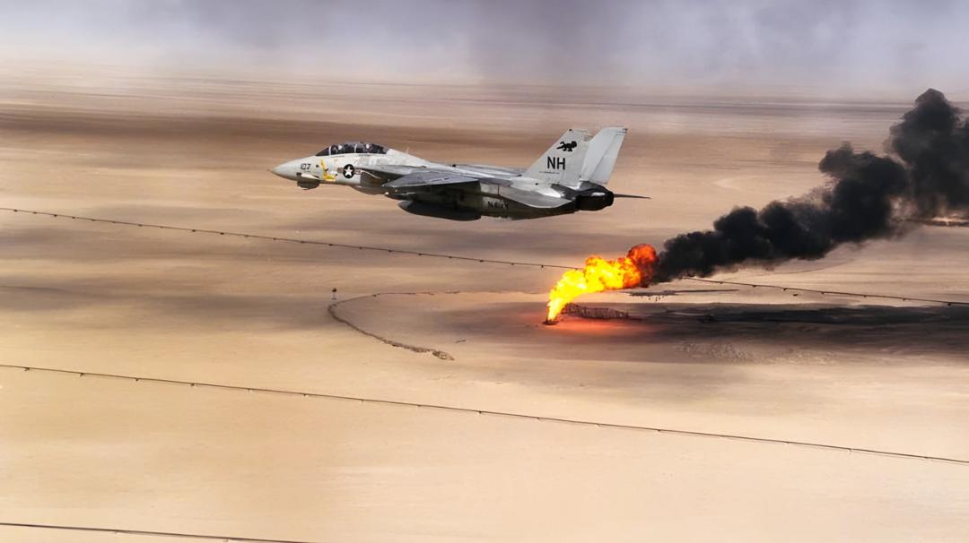 جنگنده اف-۱۴ تامکت (F-14 Tomcat) در حال پرواز بر فراز بیابان در کنار آتش