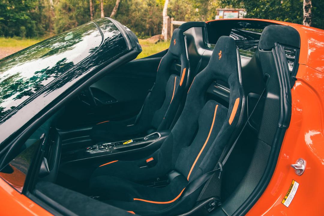 صندلی‌های اسپرت مشکی با خطوط نارنجی در کابین فراری 296 اسپشاله (Ferrari 296 Specialia)