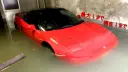 خودروی قرمز رنگ فراری (Ferrari) غرق در آب در یک پارکینگ زیرزمینی