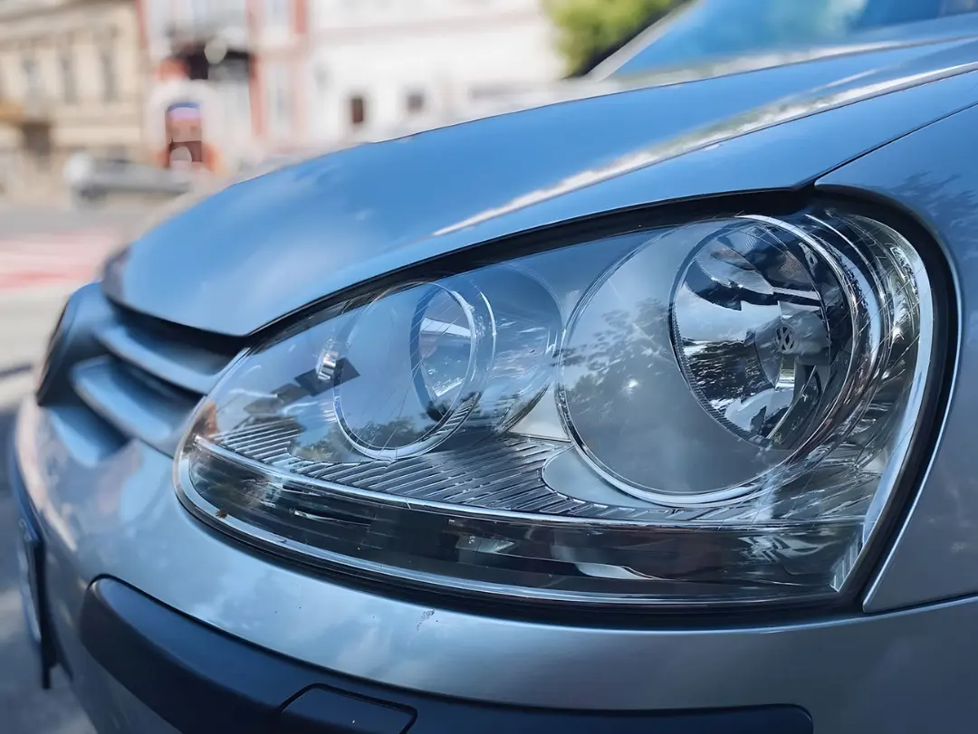 چراغ جلوی کدر یک خودروی فولکس‌واگن (Volkswagen) با سطح مات و آسیب‌دیده